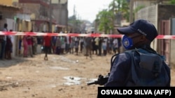 Um agente da polícia em frente a manifestantes que clamam por comida depois da quarentena imposta pelo governo em Maio, 2020. Bairro do Hoji-Ya-Henda, 8 de junho 2020