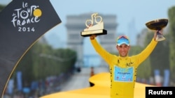 Vincenzo Nibali of Italy celebrates his overall victory on the podium after the final stage of the 2014 Tour de France on the Champs Elysees in Paris, July 27, 2014. 