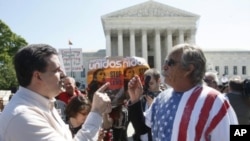 Mark Jenkins (L), an opponent of Arizona Senate Bill 1070 and Blake Sutherland (R), a supporter of the bill, discuss their opposite viewpoints outside the U.S. Supreme Court in Washington, April 25, 2012. 