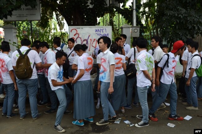 Siswa SMA Negeri 3 Jakarta merayakan kelulusan mereka dengan saling menorehkan tanda tangan atau grafiti di seragam sekolah mereka, 16 April 2014. (AFP)