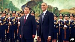 FILE - U.S. President Barack Obama, right, smiles after a group of children waved flags and flowers to cheer him during a welcome ceremony with Chinese President Xi Jinping at the Great Hall of the People in Beijing, China, Nov. 12, 2014.