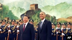 FILE - U.S. President Barack Obama, right, smiles after a group of children waved flags and flowers to cheer him during a welcome ceremony with Chinese President Xi Jinping at the Great Hall of the People in Beijing, China, Nov. 12, 2014.