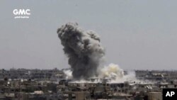 This frame grab from video provided Aug. 13, 2017, by the Ghouta Media Center, a Syrian activist media group, shows smoke and debris rising after a Syrian government ground-to-ground rocket strikes the opposition-held town of Ain Terma, in the Eastern Ghouta suburb of Damascus, Syria. 