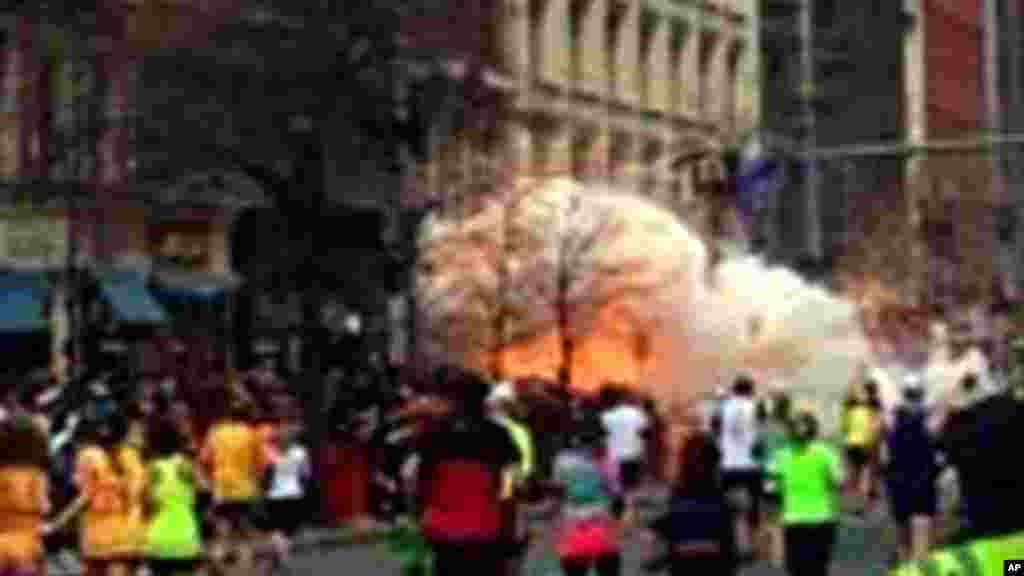 Espectadores e corredores fogem ap&oacute;s as duas explos&otilde;es durante a maratona de Boston quando muitos dos corredores e seus apoiantes se encontravam perto da linha de chegada. (15 de Abril 2013) 