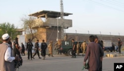 FILE - Pakistan army soldiers and other security officials surround a central jail in Bannu, 170 kilometers south of Peshawar, Pakistan. Taliban militants battled their way into this prison in 2012, freeing close to 400 prisoners.