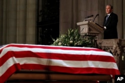 Former President George W. Bush speaks in front of the flag-draped casket of his father, former President George H.W. Bush, at the State Funeral at the National Cathedral, Dec. 5, 2018, in Washington.