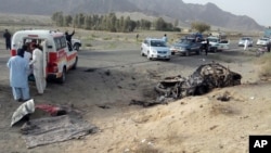 This photo taken by freelance photographer Abdul Malik on Saturday, May 21, 2016, purports to show volunteers standing near the wreckage of the destroyed vehicle, in which Mullah Mohammad Akhtar Mansour was allegedly traveling in the Ahmed Wal area in Baluchistan province of Pakistan, near Afghanistan border. A senior commander of the Afghan Taliban confirmed on Sunday that the extremist group's leader, Mullah Mohammad Akhtar Mansour, has been killed in a U.S. drone strike. (AP Photo/Abdul Malik)