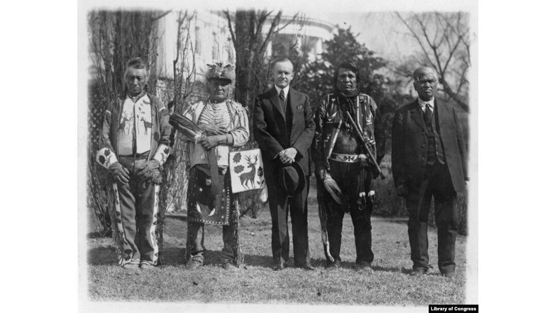 This 1925 photo shows President Calvin Coolidge posed with unidentified Native Americans, near the south lawn of the White House, shortly after passage of the Native American Citizenship Act of June 1924.