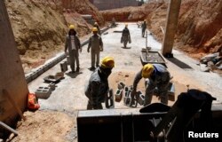 FILE - Former slaves work at a construction site in Cuiaba, Mato Grosso state, Brazil, Feb. 7, 2012.