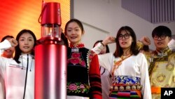 Students and volunteers take an oath of service as they stand near the Olympic flame during an event at the Beijing University of Posts and Communications in Beijing, Dec. 9, 2021. It was one of the first public events to display the flame since its arrival from Greece in October.