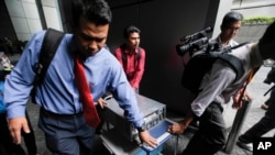 Malayziya politsiyasi davlatga qarashli jamg'arma kompyuterlarini tekshirish uchun olib ketmoqda, 8-iyul, 2015-yil.