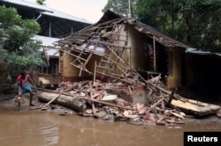 A man removes debris from a collapsed house after floods in Paravur, in the southern state of Kerala, India, Aug. 23, 2018.