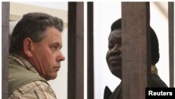 A combination photo shows Zimbabwean safari operator Honest Ndlovu (R) and fellow countryman and hunter Theo Bronkhorst waiting to appear in Hwange magistrates court, July 29, 2015.