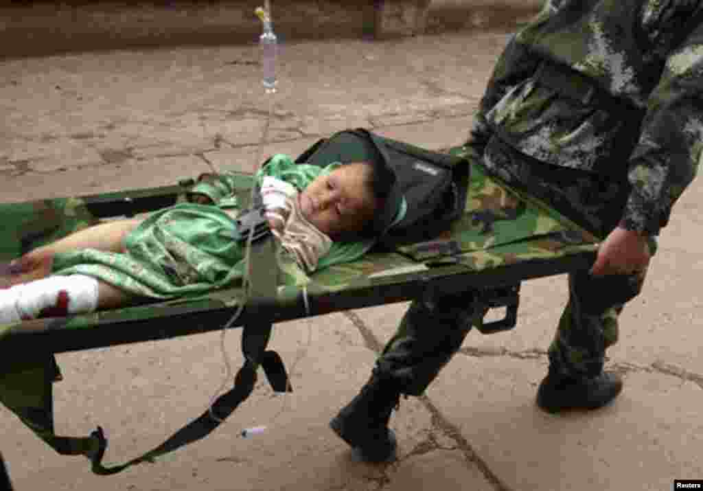 An injured child is carried by paramilitary policemen on a stretcher after an earthquake hit Longtoushan township of Ludian county, Yunnan province.