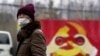 一名戴着口罩的男子走过上海街头一处中共徽标的图案。（2020年1月28日）