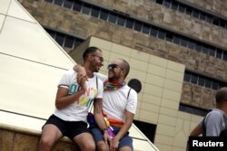 A gay couple takes part of a concentration of LGBT community members and activists in front of the Supreme Court of Justice, to demand constitutional magistrates to give a positive ruling on equal marriage in San Jose, Costa Rica, Aug. 4, 2018.