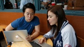 Colombian-born immigrant Nathaly Ordonez, right, studies her next semester's class options at the tuition-free, online University of the People, Thursday, Nov. 5, 2015, in New York, with Shota Hanawka, at left.