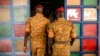 FILE - Two soldiers enter the Catholic church at the 10th RCAS army barracks in Kaya, Burkina Faso, April 10, 2021. The West African nation has been embroiled in unprecedented violence.