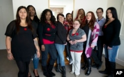 FILE - In this March 30, 2015 file photo, Makenzie Vasquez, from left, Pamala Hunt, Latonya Suggs, Ann Bowers, Nathan Hornes, Ashlee Schmidt, Natasha Hornes, Tasha Courtright, Michael Adorno and Sarah Dieffenbacher, pose for a picture in Washington, former and current college students calling themselves the “Corinthian 100” say they are on a debt strike and refuse to pay back their student loans. (AP Photo/Manuel Balce Ceneta, File)