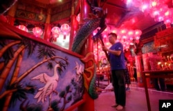 An Indonesian ethnic Chinese prays during the Lunar New Year's eve at a temple in Jakarta, Indonesia, Monday, Feb. 4, 2019. Asians around the world will be celebrating the start of the Year of Pig on Feb. 5 this year in the lunar calendar. (AP Photo/Achma