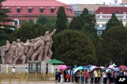 FILE - Visitors line up on Tiananmen Square on a rainy day in Beijing, June 4, 2015. In what's become an annual ritual, Chinese police were stepping up their vigilance in the capital Thursday to prevent any remembrance of the event.