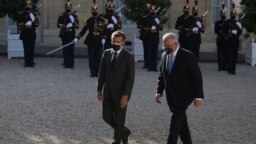 FILE - French President Emmanuel Macron, left, welcomes Australia's Prime Minister Scott Morrison before a working dinner in Paris, June 15, 2021. 