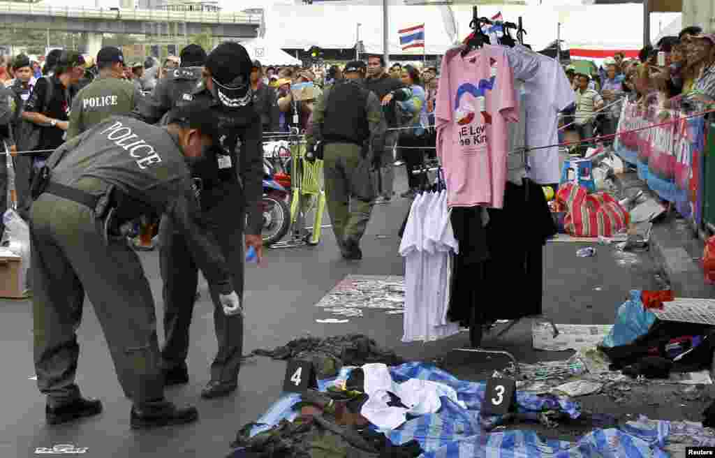 Police officers investigate the scene where an explosion took place near a camp of anti-government protesters at the Victory Monument in Bangkok, Jan. 19, 2014. 