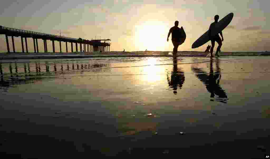 미국 캘리포니아주 샌디에고 스크립스 항구 인근에서 서핑을 끝낸 시민들이 물 속을 걸어나오고 있다. 스크립스 해양학 연구소는 샌디에고 해수면이 지난 102년동안 관측된 적 없는 가장 높은 온도를 기록했다고 밝혔다.