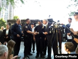 New York City Police Commissioner Bill Bratton greets Sgt. Hameed Armani, right, and Officer Peter Cybulski at a news conference at Columbus Circle in New York, July 21, 2016.