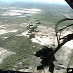 This image taken from video shows relief supplies parachuting from a US Air Force cargo plane flying over Haiti, 19 January 2010 Author: US Air Force