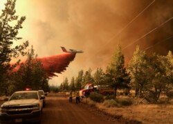 This photo provided by the Oregon Department of Forestry shows a firefighting tanker making a retardant drop over the Grandview Fire near Sisters, Ore., Sunday, July 11, 2021.