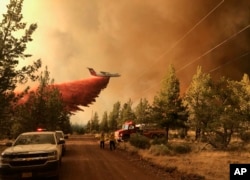 Sebuah pesawat terbang tanker pemadam kebakaran berupaya memadamkan api di kawasan kebakaran Grandview Fire dekat Sisters, Oregon, Minggu, 11 Juli 2021. (AP/Departemen Kehutanan Oregon)