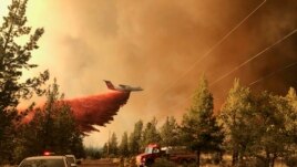 This photo provided by the Oregon Department of Forestry shows a firefighting tanker making a retardant drop over the Grandview Fire near Sisters, Ore., Sunday, July 11, 2021.