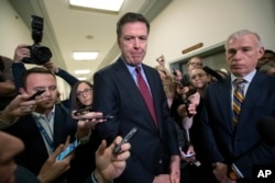 FILE - Former FBI Director James Comey, with his attorney, David Kelley, right, speaks to reporters after a day of testimony before the House Judiciary and Oversight committees, on Capitol Hill in Washington, Dec. 7, 2018.