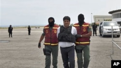 National Guard officers escort Colombia's suspected drug trafficker Jaime Alberto Marin, center, aka "Beto Marin", allegedly the boss of the Norte del Valle cartel, before being extradited to the US, at the Simon Bolivar airport in Maiquetia, Venezuela, 2