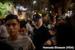 FILE - Policewomen show up on duty at movie theaters to organize crowds and protect girls from possible sexual harassment in downtown Cairo, Egypt, June 15, 2018.