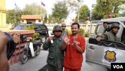 Mr. Meach Sovanara, an activist of the Cambodia National Rescue Party (CNRP) is escorted while he was brought to the supreme court on Wednesday, March 4, 2015. (Heng Reaksmey/VOA Khmer)