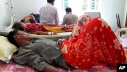 In this May 6, 2018, photo provided by Cambodia National Police, patients lie on beds at a hospital in Kratie province in northeast of Phnom Penh, Cambodia.