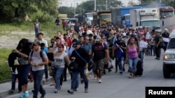 A large group of Hondurans fleeing poverty and violence march toward the United States, in San Pedro Sula, Honduras, Oct. 13, 2018.