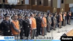 FILE - The trial of three people sentenced to death for their roles in an October attack on the edge of Beijing's Tiananmen Square is seen in this still image taken from video in Urumqi city, June 16, 2014. 