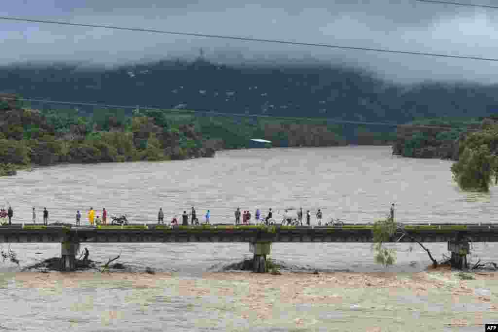 People watch the Humuya river flooding due to heavy rains caused by Eta Hurricane, in Santa Rita, Yoro department, 240 kilometers northern Tegucigalpa, Nicaragua, Nov. 3, 2020.