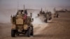 FILE - An American military convoy proceeds during a joint exercise with Syrian Democratic Forces at the countryside of Deir el-Zour in northeastern Syria, Dec. 8, 2021.