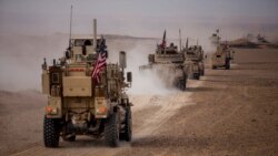 FILE - An American military convoy proceeds during a joint exercise with Syrian Democratic Forces at the countryside of Deir el-Zour in northeastern Syria, Dec. 8, 2021.