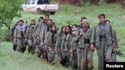 Pemberontak dari Partai Pekerja Kurdi (PKK) berjalan menuju pangkalan baru mereka di utara Ira (14/5). Kelompok pertama militan Kurdi menarik diri dari Turki sebagai satu langkah perjanjian damai antara pemimpin PKK yang dipenjara, Abdullah Ocalan, dengan para pejabat Turki untuk mengakhiri konflik yang telah berlangsung selama 30 tahun.