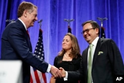 FILE - U.S. Trade Representative Robert Lighthizer, left, shakes hands with Mexico's Secretary of Economy Ildefonso Guajardo, accompanied by Canadian Foreign Affairs Minister Chrystia Freeland, after attending a news conference at the start of NAFTA renegotiations in Washington, Aug. 16, 2017.