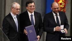 European Council President Herman Van Rompuy, European Commission President Jose Manuel Barroso, and European Parliament President Martin Schulz (L-R) are pictured with the Nobel diploma on the podium in Oslo City Hall during Nobel Peace Prize ceremony De