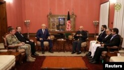 FILE - Afghanistan's President Ashraf Ghani, right, and U.S. special envoy for peace in Afghanistan, Zalmay Khalilzad, left, meet in Kabul, Nov.10, 2018. 
