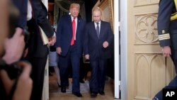 Le président américain Donald Trump, à gauche, et le président russe Vladimir Poutine arrivent pour une rencontre en tête-à-tête au palais présidentiel d'Helsinki, en Finlande, le 16 juillet 2018.