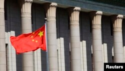 FILE- A Chinese national flag flaps in the wind outside the Great Hall of the People in Beijing.