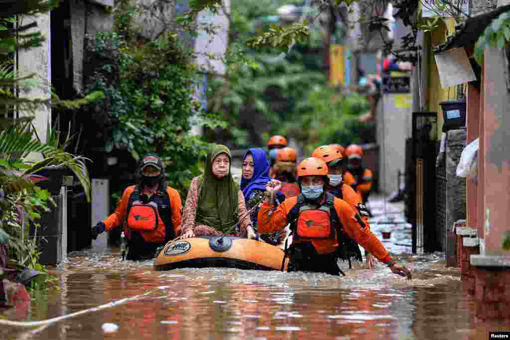 Volunteers evacuate elderly women with an inflatable boat in an area affected by floods, following heavy rains in Jakarta, Indonesia, in this photo taken by Antara Foto.